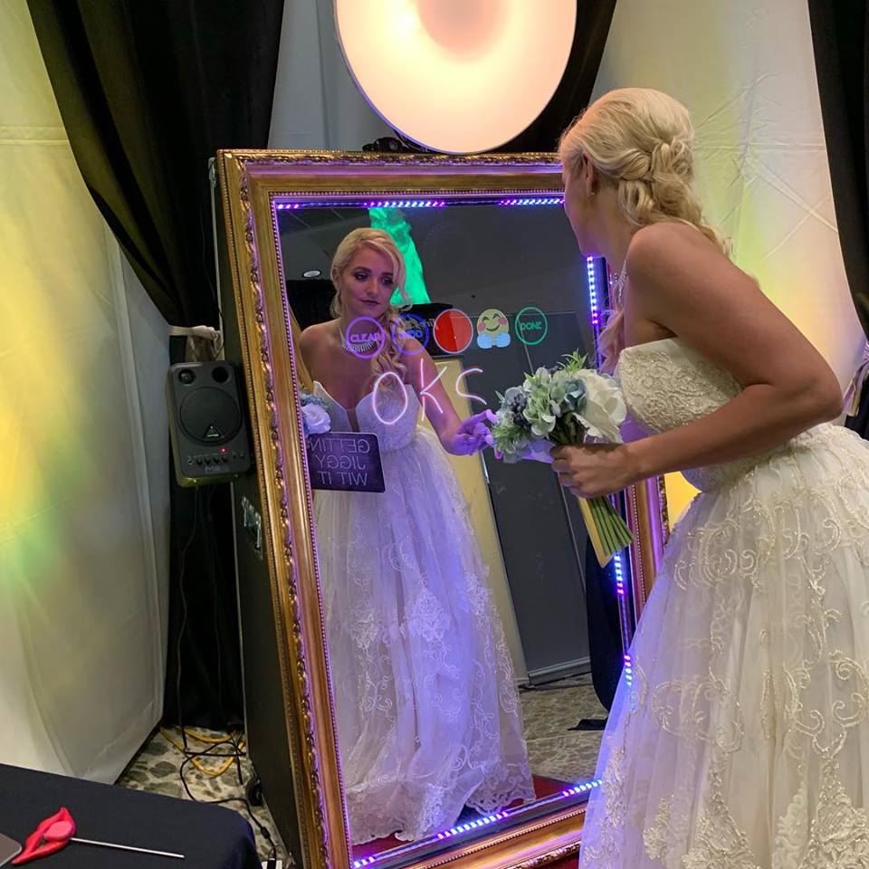 mirror photo booth rental with bride taking a picture